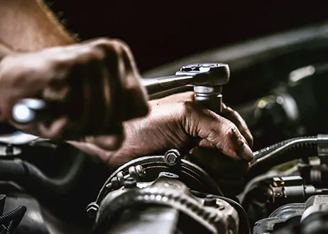 Man turning wrench inside engine bay